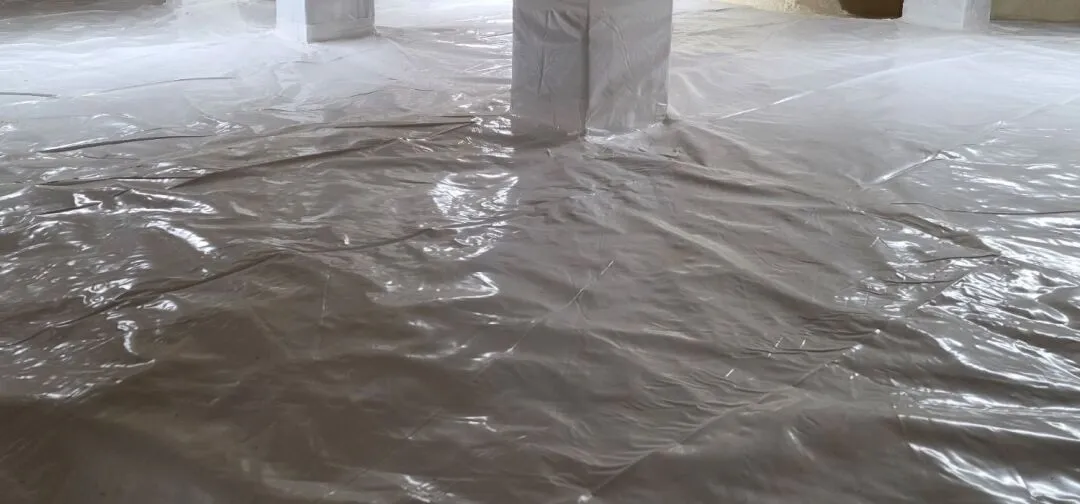 A crawl space floor and support columns covered with a smooth, sealed sheet of plastic vapor barrier ensure optimal protection—choose the right crawl space vapor barrier thickness for lasting durability.