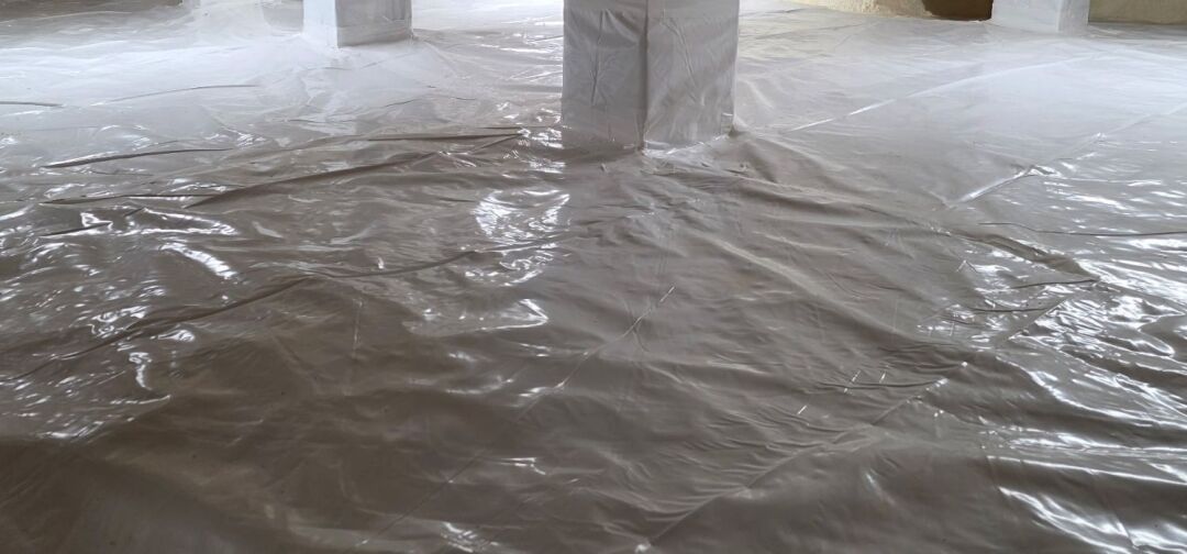 A crawl space floor and support columns covered with a smooth, sealed sheet of plastic vapor barrier ensure optimal protection—choose the right crawl space vapor barrier thickness for lasting durability.