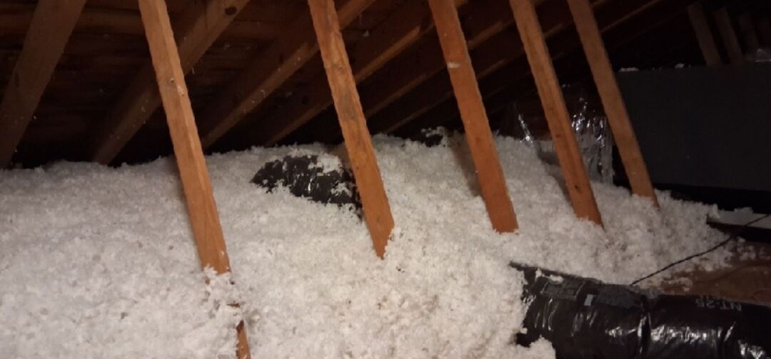 Blown-in insulation installed in the attic of a historic home to improve energy efficiency while preserving the structure.